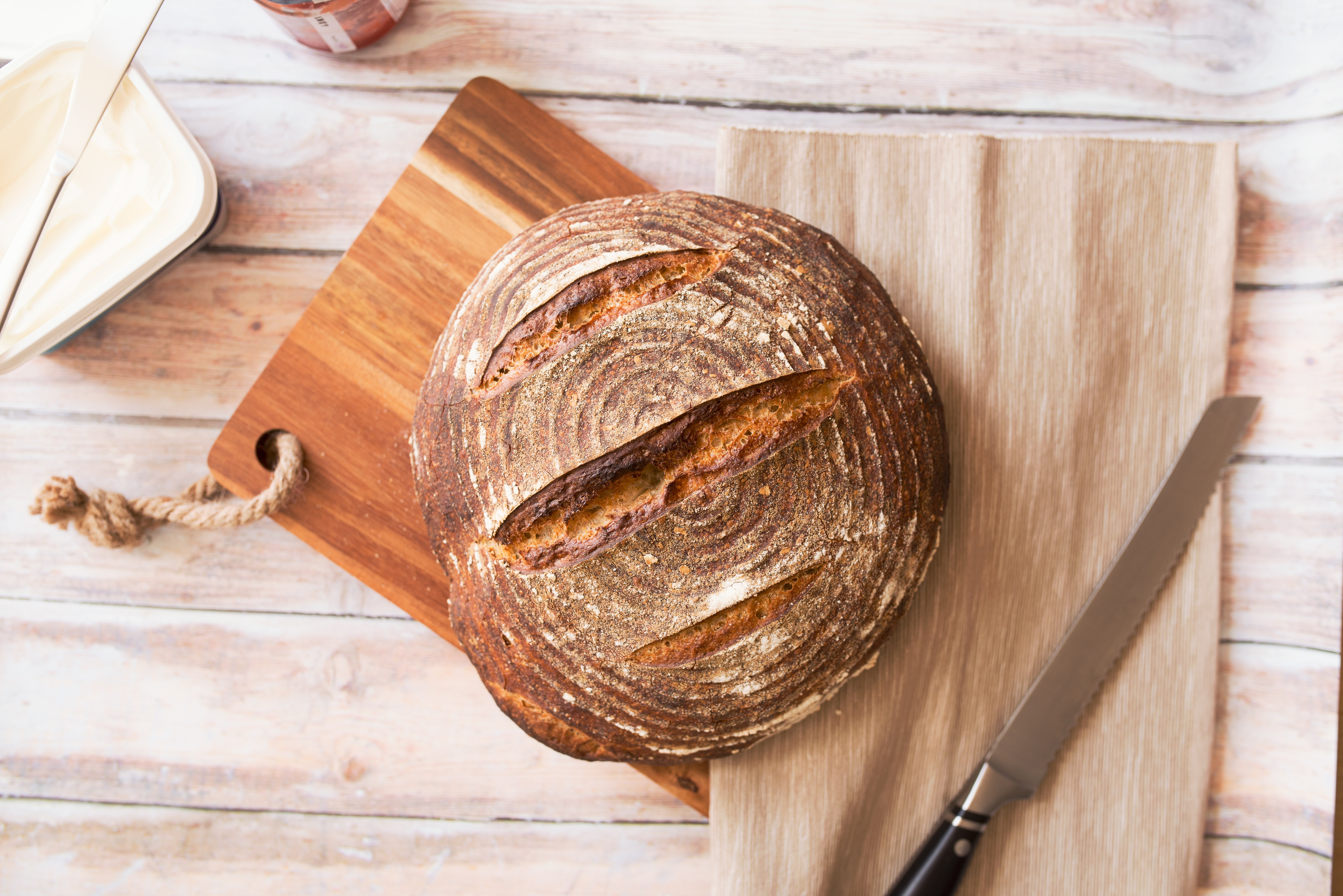 A sourdough loaf of bread on a cutting board.
