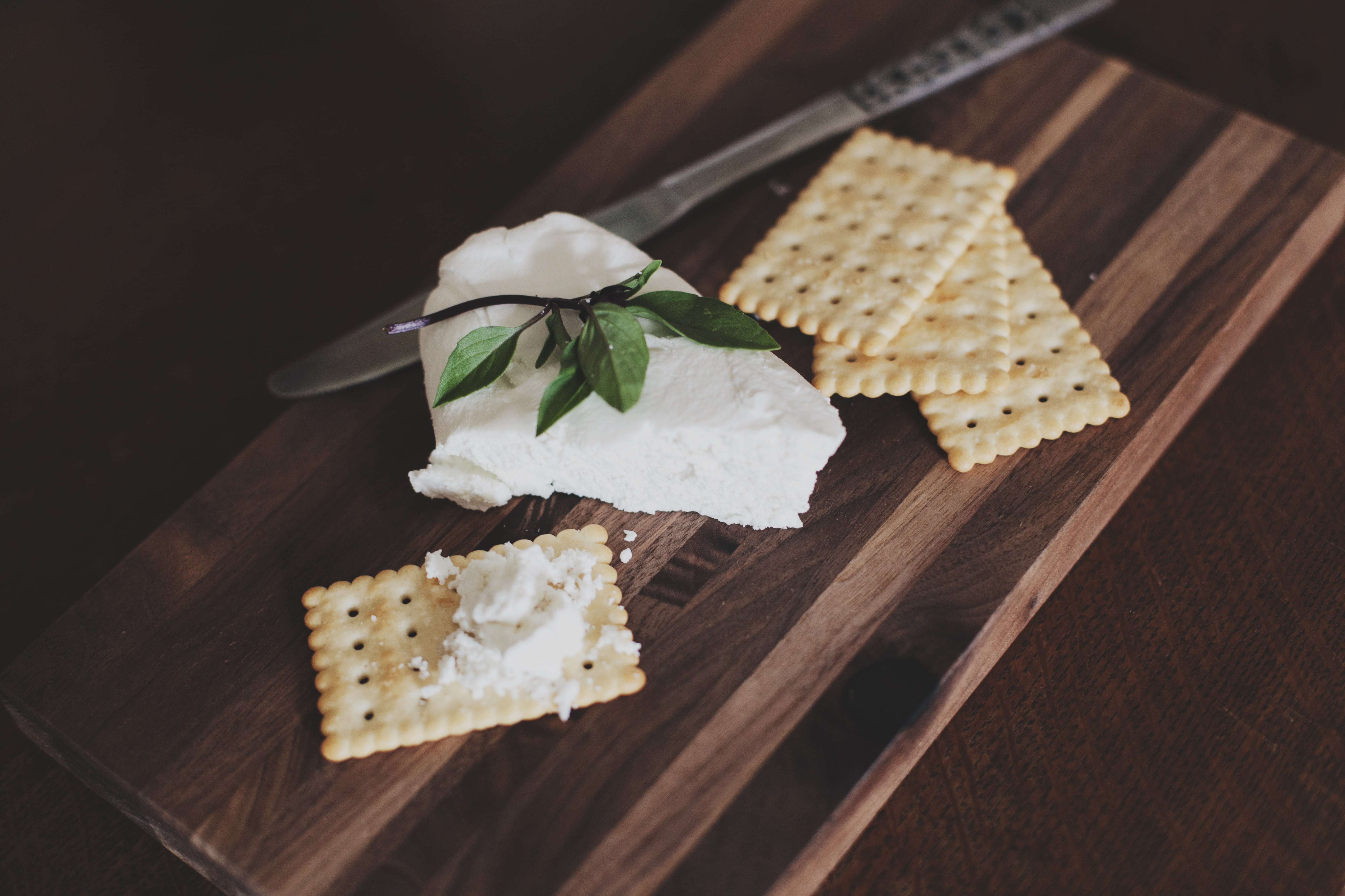 A cheese board with goat cheese and crackers.